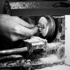 A craftsman's hand using a grinding tool in a workshop, depicting precision and craftsmanship.